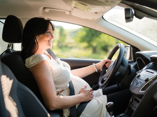 Pregnant woman driving with safety belt on in the car