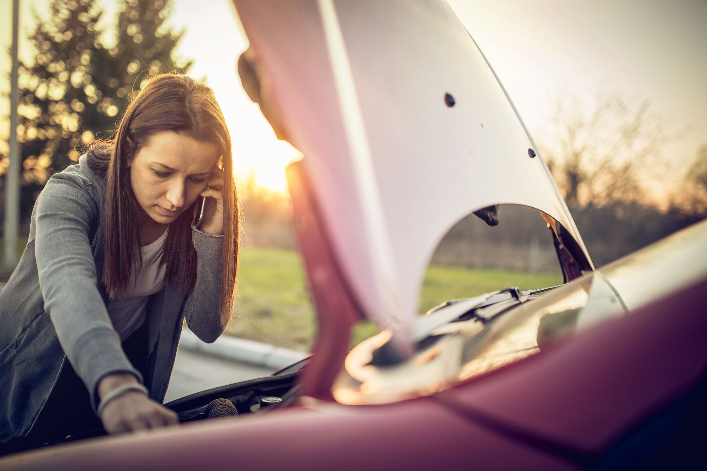 mujer-revisando-su-carro-y-hablando-por-telefono-card.jpg.img.2400.1565987909424