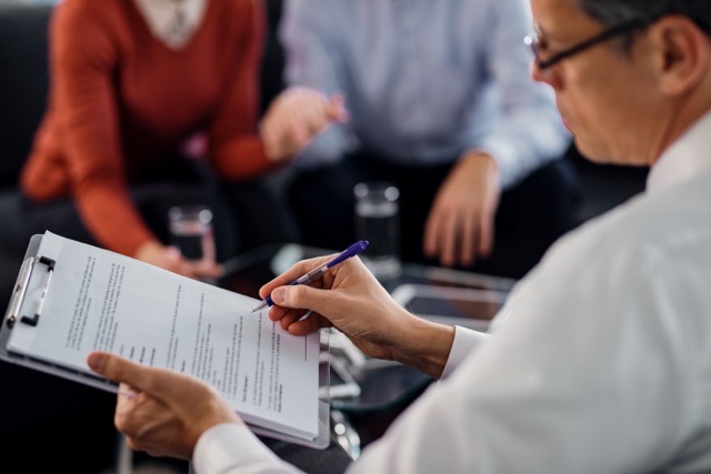 closeup-agent-going-through-lease-agreement-while-having-meeting-with-his-clients de tamaño mediano